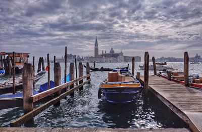 View of boats moored in sea against cloudy sky