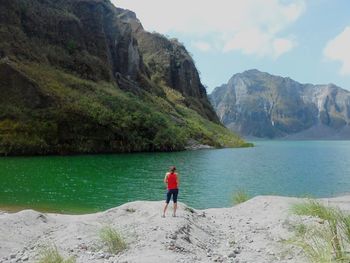 Man standing on cliff by sea