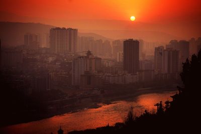 Modern buildings against sky during sunset in city