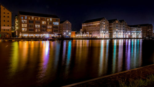Bridge over river in city at night