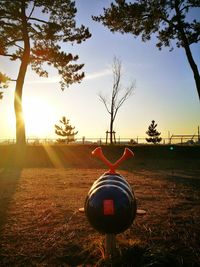 Close-up of cross on field against sky during sunset