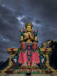 Low angle view of statue against building against sky