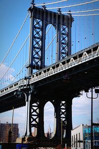Low angle view of suspension bridge against sky