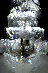 Low angle view of illuminated lighting equipment on glass