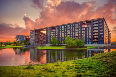 Modern residential building  in  city area with lake and green grass at sunset. copenhagen, denmark