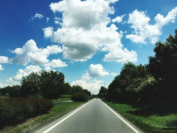 Road amidst trees against sky