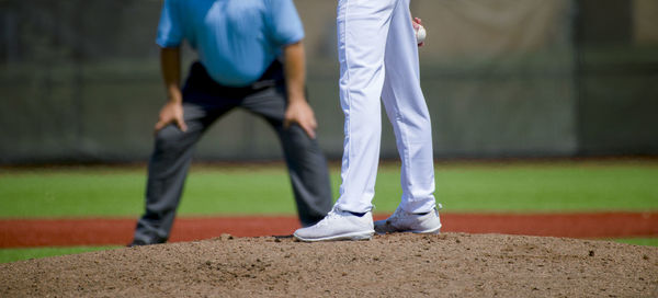 Low section of men playing baseball on field