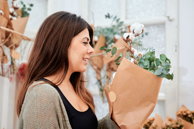 Portrait of young woman holding plant