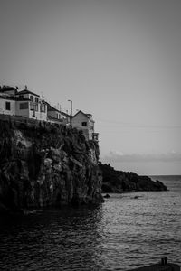 Scenic view of sea by buildings against clear sky