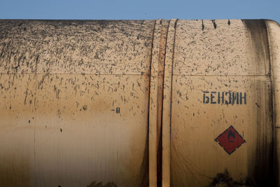 Close-up of text on wall against sky