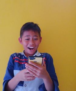 Portrait of smiling boy holding mobile phone