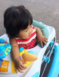 High angle view of boy playing with toy car