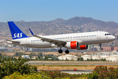 Airplane flying over mountains against clear sky