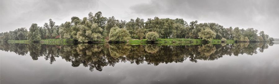 Reflection of trees in lake against sky