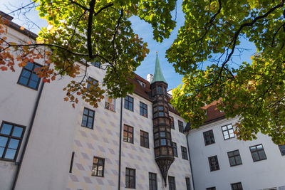 Low angle view of trees and building against sky