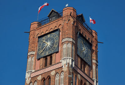 Low angle view of clock tower against clear blue sky