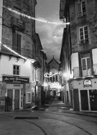 Street amidst buildings in city at night