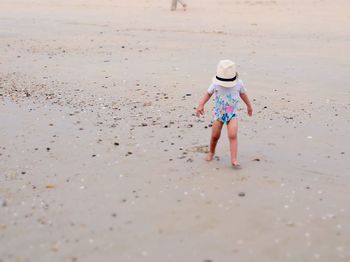 Rear view of kid walking on beach