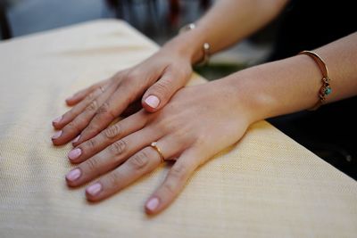 Cropped image of woman hands on table at outdoors cafe