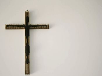 Cross on wall against clear sky