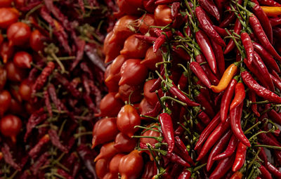 Full frame shot of red chili peppers and cherry-tomatoes