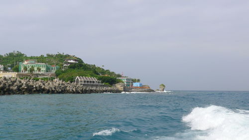 Scenic view of sea and buildings against sky