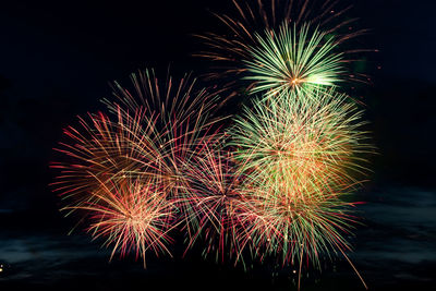 Low angle view of firework display at night