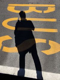 Shadow of person on yellow umbrella