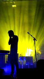 Man with arms outstretched at music concert