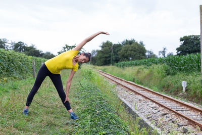 Full length of woman exercising on field