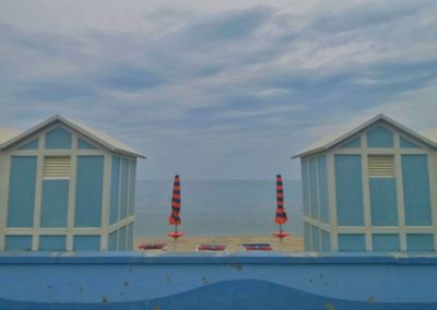 Buildings by sea against sky