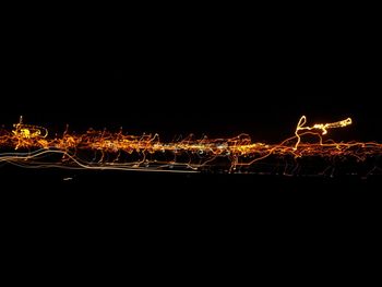 Illuminated firework display against sky at night