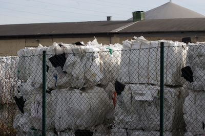 Garbage by fence against building