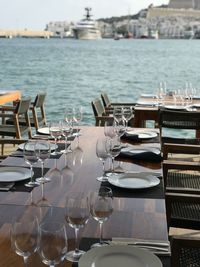 Chairs and tables at restaurant by sea at ibiza marina