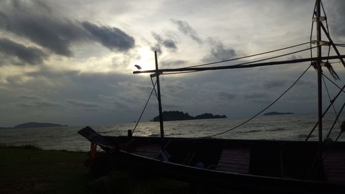 Silhouette sailboats moored on sea against sky