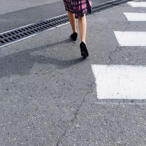 Low section of woman walking on street