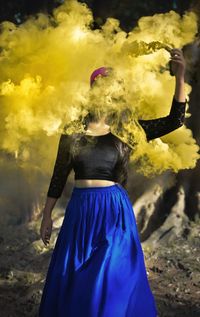 Woman holding smoking pipe outdoors