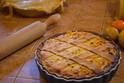 High angle view of pie by rolling pin on kitchen counter