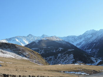 Scenic view of snowcapped mountains against clear blue sky