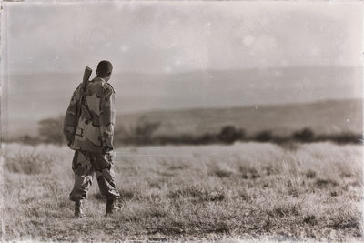 Rear view of man walking on field