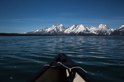 Scenic view of sea and snowcapped mountains against sky