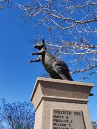 Low angle view of a statue against blue sky