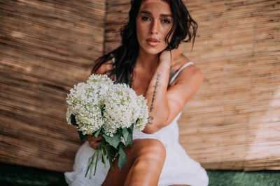 Portrait of woman holding flower bouquet