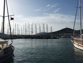 Boats moored at harbor against sky