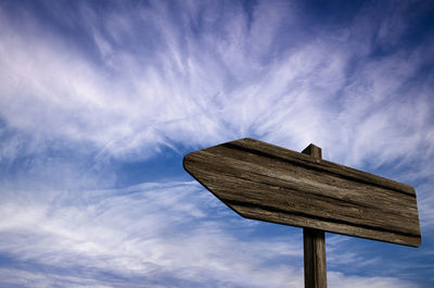 Low angle view of wooden post against sky