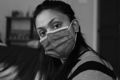 Portrait of woman at home wearing mask during pandemic 