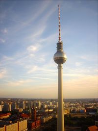 Fernsehturm and buildings in city against sky