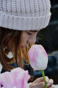 Close-up of woman holding pink flower