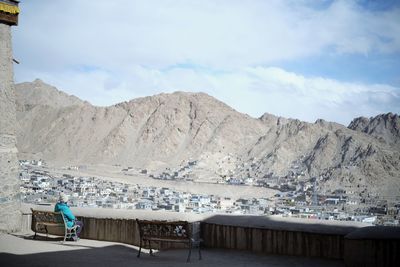 Empty chairs and table against mountains against sky