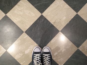 Low section of person standing on tiled floor